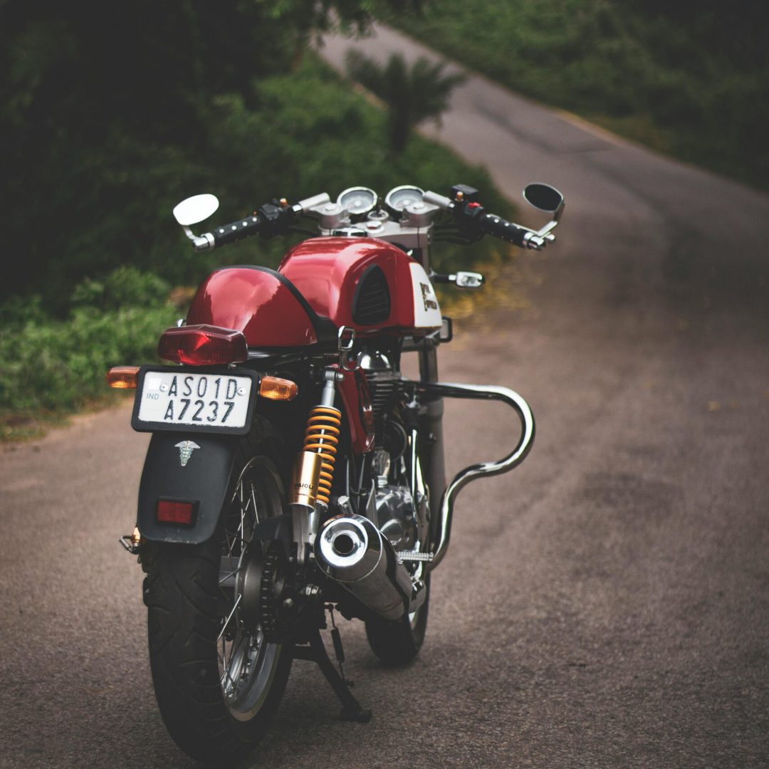 pexels-photo-1715184-1715184 Rear view of a classic red motorcycle parked on a quiet country road, showcasing vintage style.